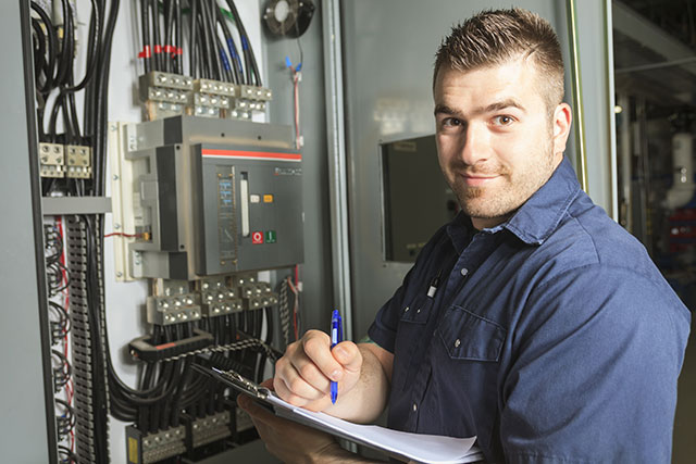 Electrician taking notes from panel information
